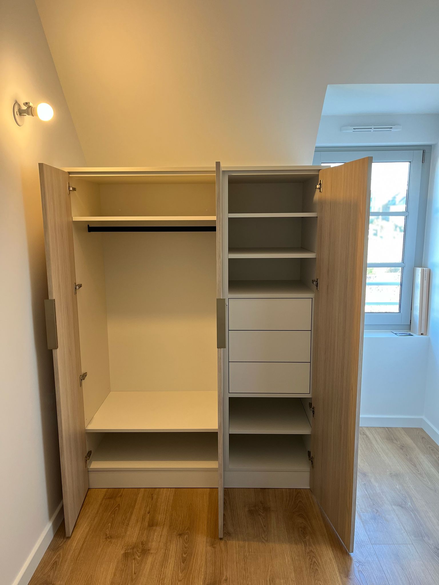 Réalisation d'un dressing en mélaniné blanc porcelaine et portes en mélaminé chêne avec tiroirs intégrés à Dinard. par Hugo Pauchard - HP Bois Menuiserie - Saint-Malo