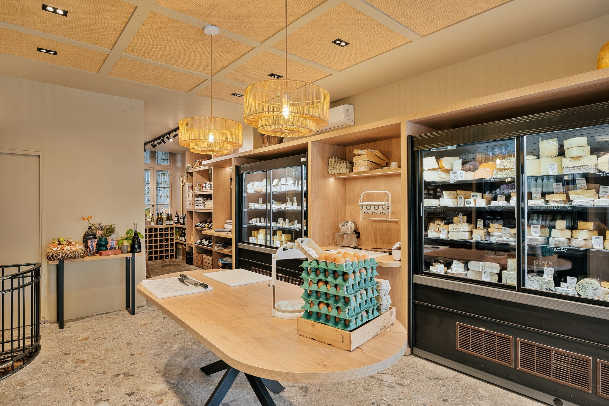 Chez les fromagers malouins, à Saint-Servan création d'une table de découpe centrale et d'un linéaire de présentation avec LED intégrées en mélanine et stratifié chêne. par Hugo Pauchard - HP Bois Menuiserie - Saint-Malo