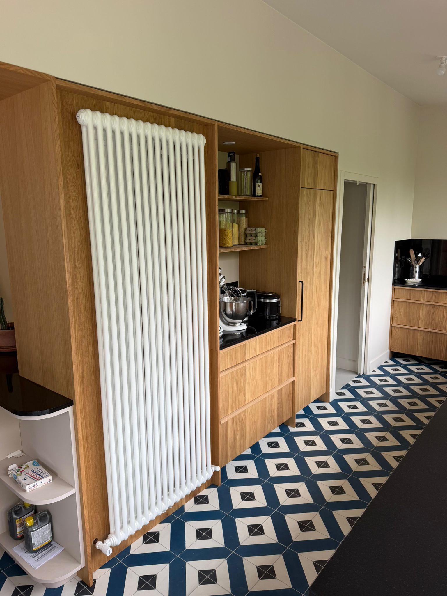Nouvelle réalisation d'une cuisine sur mesure près de Saint-Malo, pensée pour conjuguer l'authenticité du bois et la modernité des touches de noir et de carrelage géométrique. Ses espaces dédiés et son ouverture sur l’extérieur en font un lieu de vie aussi pratique qu'esthétique au quotidien. - CCM Agencement - Saint-Malo